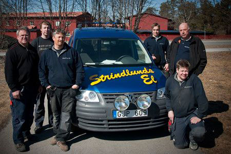 Strindlunds els medarbetare tillsammans vid en blå arbetsbil